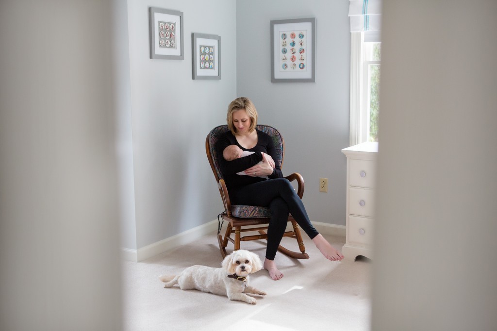 Mom holding baby with dog guarding